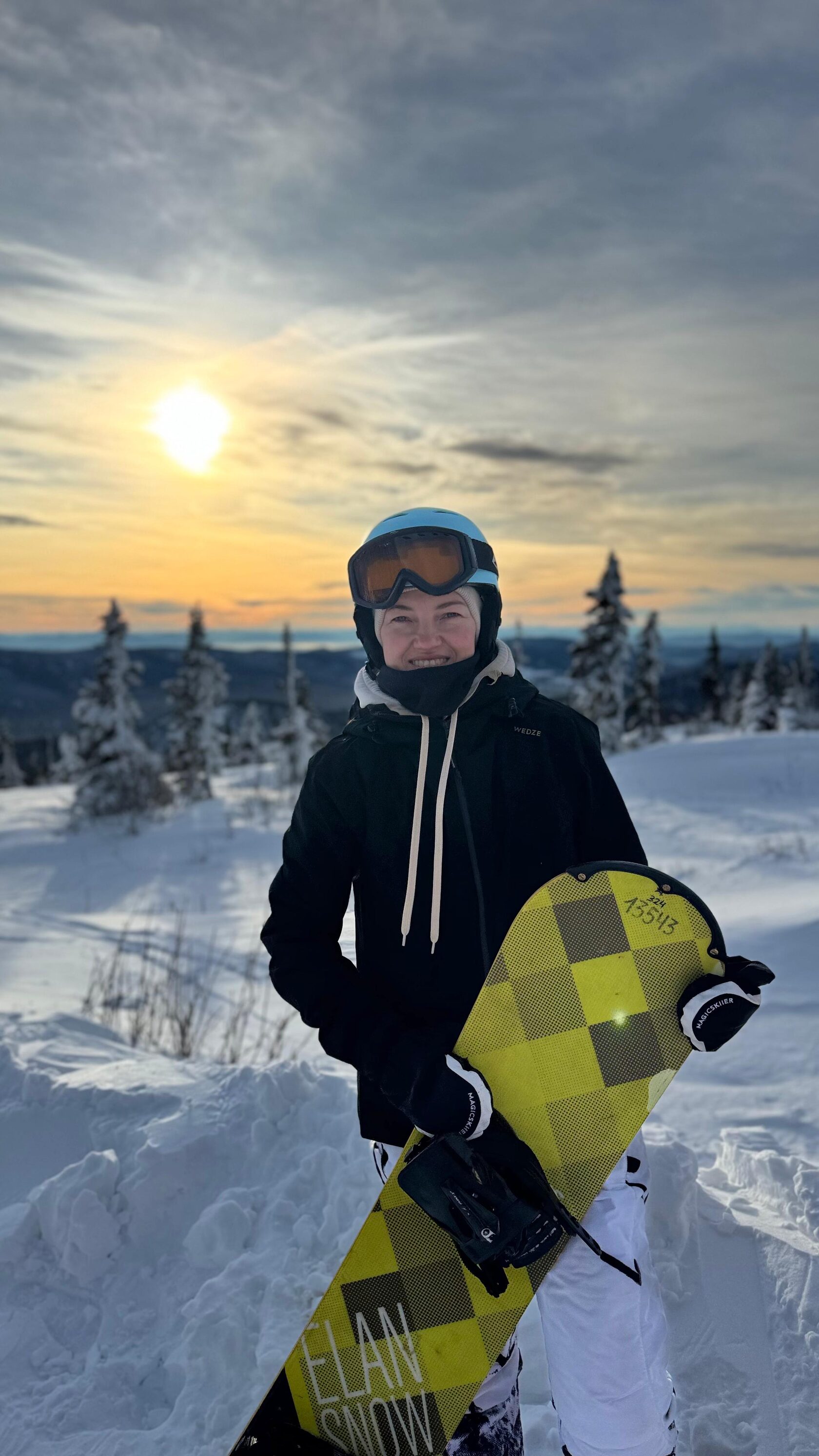 Сноубордистка на закате в горах